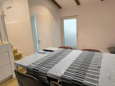 a room with a table with chairs and a keyboard at Love 2 Solkan in Nova Gorica