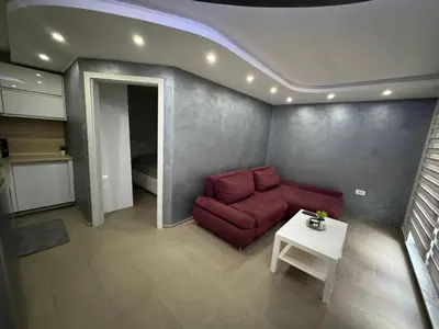 a living room with a red couch and a table at Koper apartma okolica in Koper