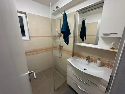 a bathroom with a shower and a sink and a mirror at Koper apartma okolica in Koper