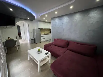 a living room with a red couch and a table at Koper apartma okolica in Koper