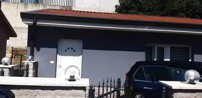 a blue and white house with a car parked in front at Koper apartma okolica in Koper