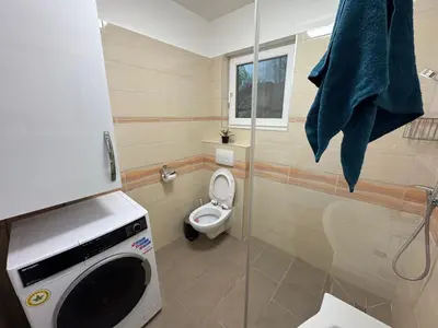 a bathroom with a toilet and a shower with a microwave at Koper apartma okolica in Koper
