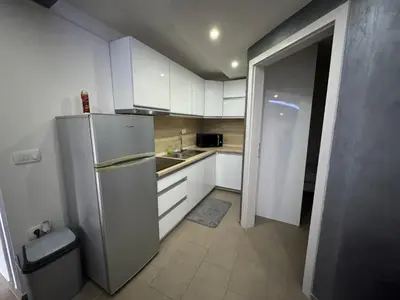 a kitchen with white cabinets and a refrigerator at Koper apartma okolica in Koper