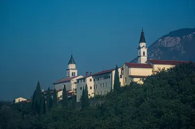 a building on top of a hill with two towers at Hiša Margarita in Ajdovščina