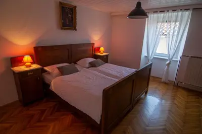 a bedroom with a large bed with two lamps on it at Hiša Margarita in Ajdovščina