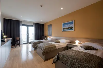 a hotel room with three beds in it at Hotel Florjančkov Hram in Ljubljana