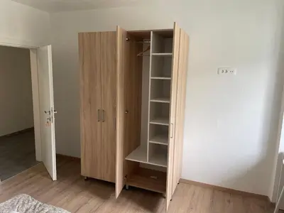 a wooden book shelf in a room with a closet at VP sobe in Ilirska Bistrica