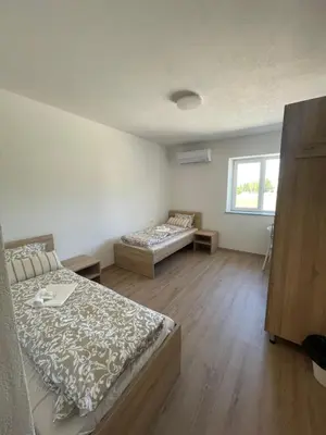 a bedroom with two beds and a window at VP sobe in Ilirska Bistrica