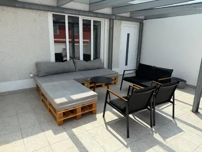a patio with a couch and a table and chairs at BIG DUPLEX Terrace FREE PARKING City Center in Ljubljana