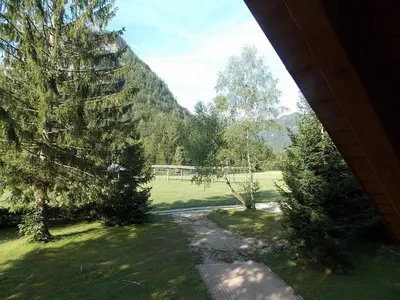 a view of a field and trees from a house at Holiday House Kaja in Mojstrana