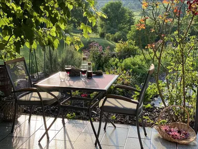 a table with two chairs and glasses of wine at Studio apartment in nature with sauna in Postojna