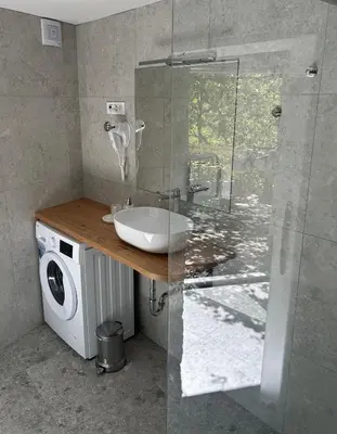 a bathroom with a sink and a washing machine at Studio apartment in nature with sauna in Postojna