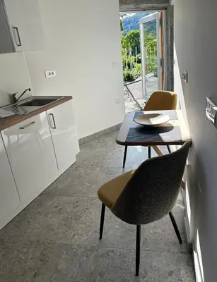 a kitchen with a table and two chairs and a table at Studio apartment in nature with sauna in Postojna