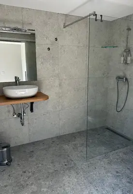 a bathroom with a glass shower and a sink at Studio apartment in nature with sauna in Postojna