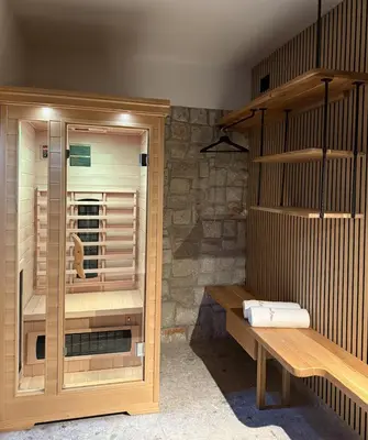 a sauna with a wooden bench in a room at Studio apartment in nature with sauna in Postojna