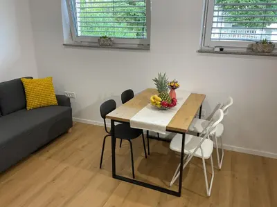 a living room with a table and chairs and a couch at Apartma Tomy in Domžale