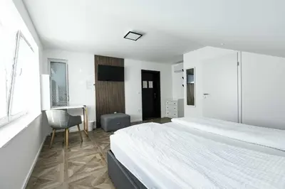 a bedroom with two beds and a desk and a chair at Sleepoteca in Šentilj