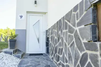 a white door on the side of a house at Sleepoteca in Šentilj
