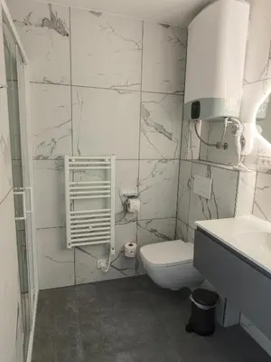 a white bathroom with a toilet and a sink at Sleepoteca in Šentilj