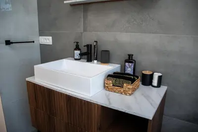a bathroom with a white sink and a basket with bottles at Vila Altura- Luxury Hiltop Retreat with Panoramic View & Teracce in Rogaška Slatina