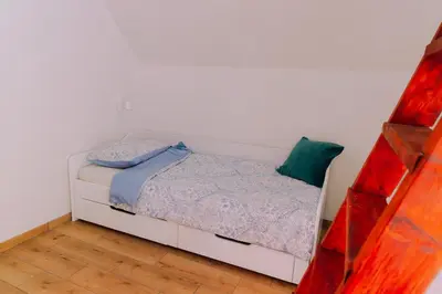 a bedroom with a white bed with a green pillow at Apartma BoMa in Bovec