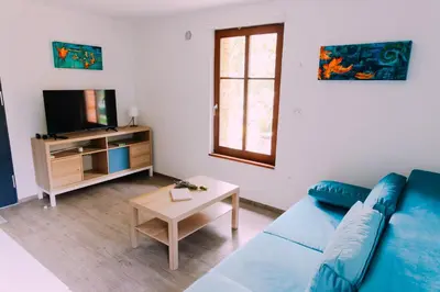 a living room with a blue couch and a tv at Apartma BoMa in Bovec
