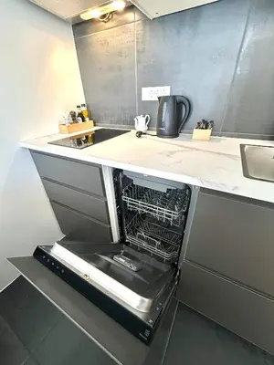 a kitchen with an open dishwasher in a counter at K-12 Loft Apartments in Ljubljana