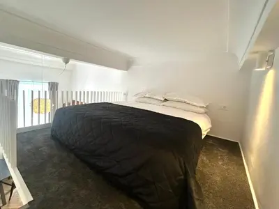 a bedroom with a bed with black sheets and white pillows at K-12 Loft Apartments in Ljubljana