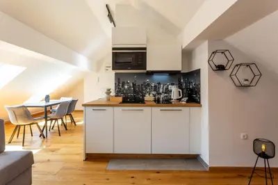 a kitchen with white cabinets and a table with chairs at Vila Slovenka in Celje