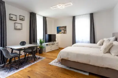 a bedroom with a bed and a desk and a television at Vila Slovenka in Celje