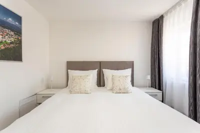 a bedroom with a large white bed with white pillows at Vila Slovenka in Celje