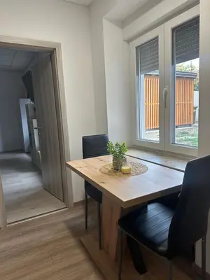 a dining room with a wooden table and chairs at Apartma Center Ljutomer in Ljutomer