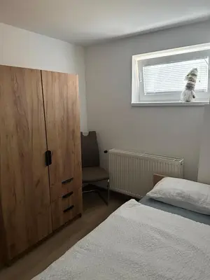 a bedroom with a bed and a dresser and a window at Apartma Center Ljutomer in Ljutomer