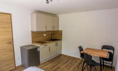 a kitchen with a table and a small table and chairs at Stara ribogojnica & Pohorska postrv in Ruše