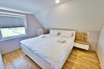 a bedroom with a large bed with two teddy bears on it at Apartma Mars in Brest