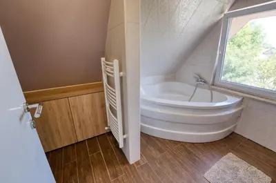 a bathroom with a white tub and a window at Apartma Mars in Brest