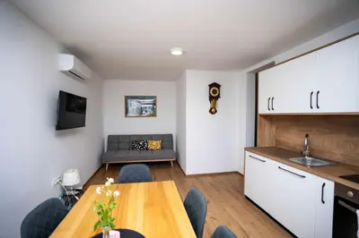 a kitchen and living room with a table and a couch at Holiday House Konuško in Šmarje pri Jelšah