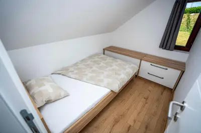 a small bedroom with a bed and a window at Holiday House Konuško in Šmarje pri Jelšah