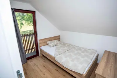 a small bedroom with a bed and a window at Holiday House Konuško in Šmarje pri Jelšah