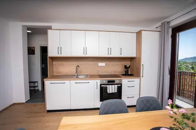 a kitchen with white cabinets and a sink at Holiday House Konuško in Šmarje pri Jelšah