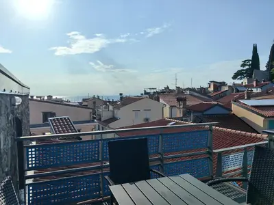 a balcony with a table and a view of a city at Rosa di Pirano con Terrazza in Rove