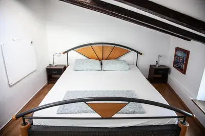 a bedroom with a large bed with a wooden headboard at Rosa di Pirano con Terrazza in Rove
