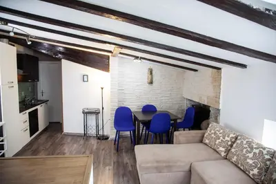 a living room with a couch and a table with blue chairs at Rosa di Pirano con Terrazza in Rove