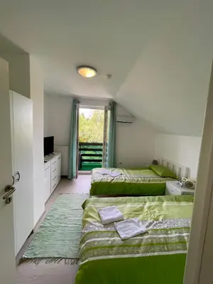 a bedroom with two beds and a window at Quiet Forest Retreat with Pool in Borovnica