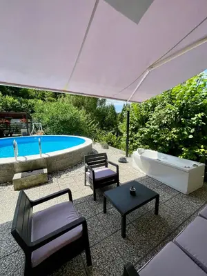 an outdoor patio with a tub and a bath tub at Quiet Forest Retreat with Pool in Borovnica