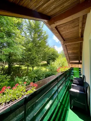 a balcony with a view of a garden at Quiet Forest Retreat with Pool in Borovnica