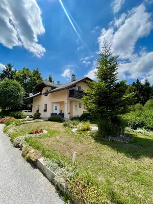 a house with a tree on the side of the road at Quiet Forest Retreat with Pool in Borovnica