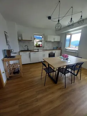 a kitchen with a table and chairs in a room at Apartma ARNEJ in Kobarid