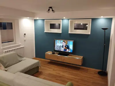a living room with a tv on a blue wall at Apartma ARNEJ in Kobarid