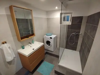 a bathroom with a sink and a washing machine at Apartma ARNEJ in Kobarid